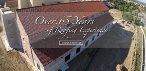 An overhead view of a construction project with a building with a red roof. Text over the image says "Over 65 Years of Roofing Experience" and "View Our Services."