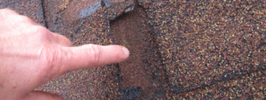 Roofer pointing out hail damage on roof