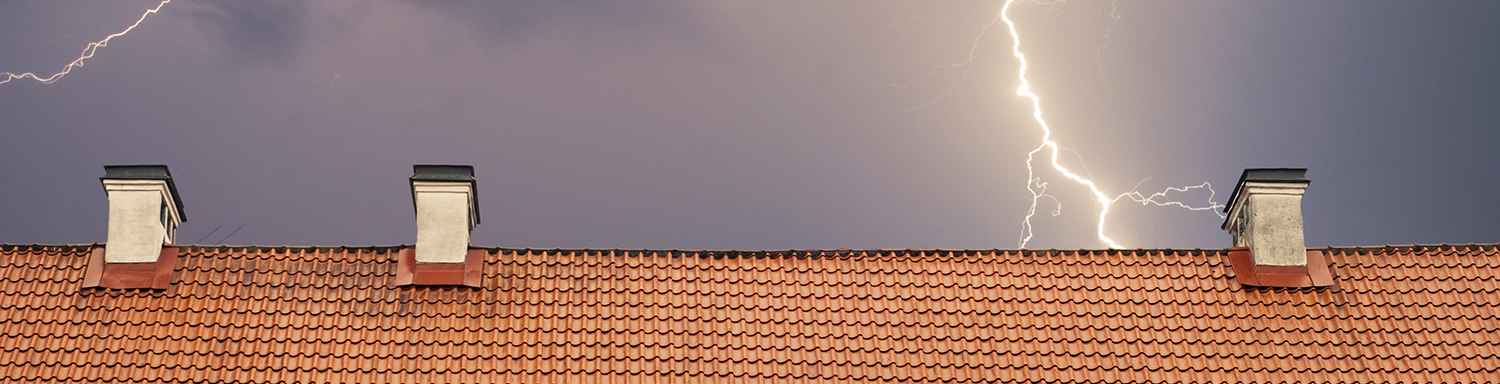lightning near a bright orange tile roof