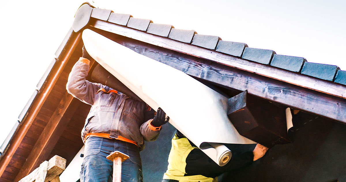 Man putting up lining on rooftop