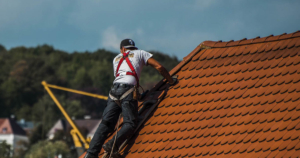 Man on roof fixing shingles