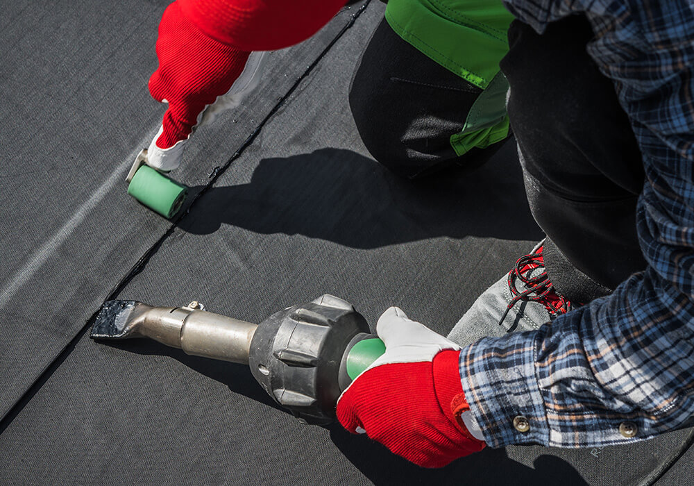 Roofer installing commercial roofing membrane